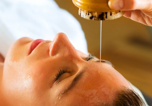 Woman enjoying a Ayurveda oil massage treatment in a spa